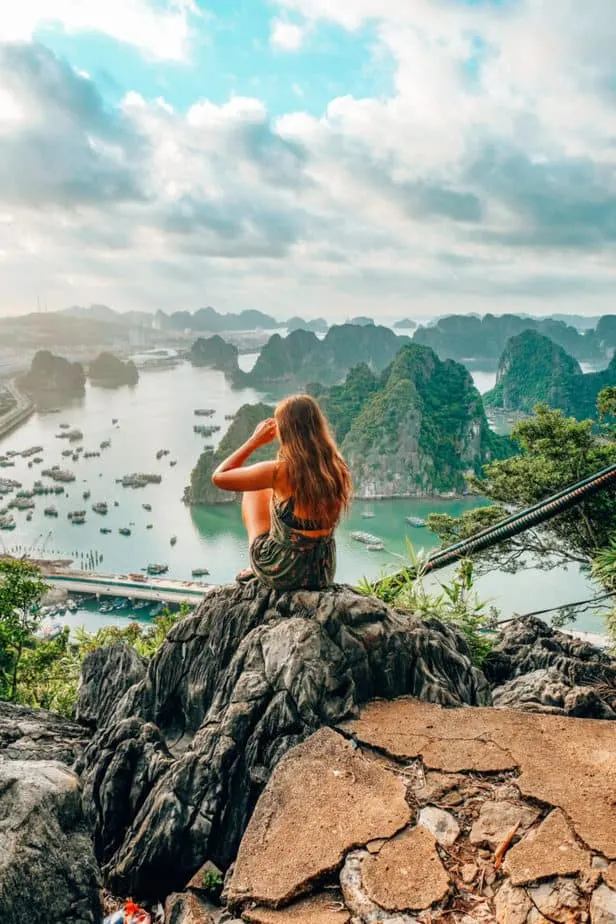 Girl sitting on a rock in front of Ha Long Bay 