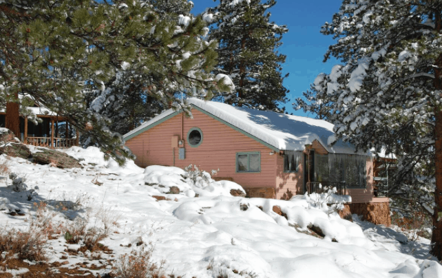 pink cabin covered in snow