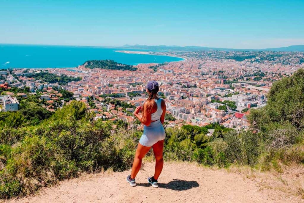 a girl standing in front of a viewpoint of Nice, France