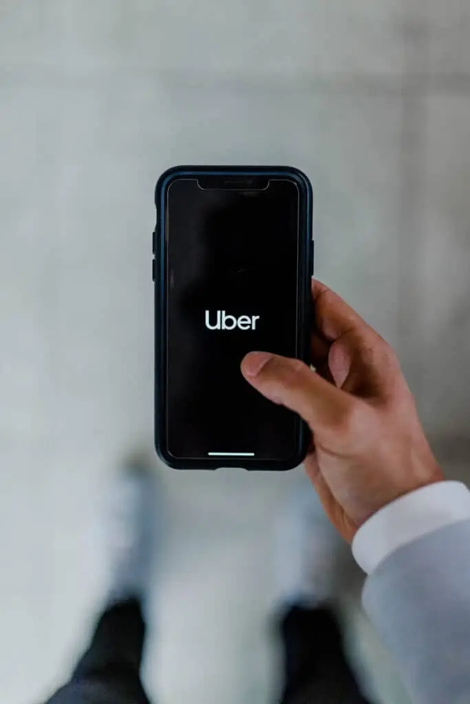 a man holding a phone with the Uber app pulled up