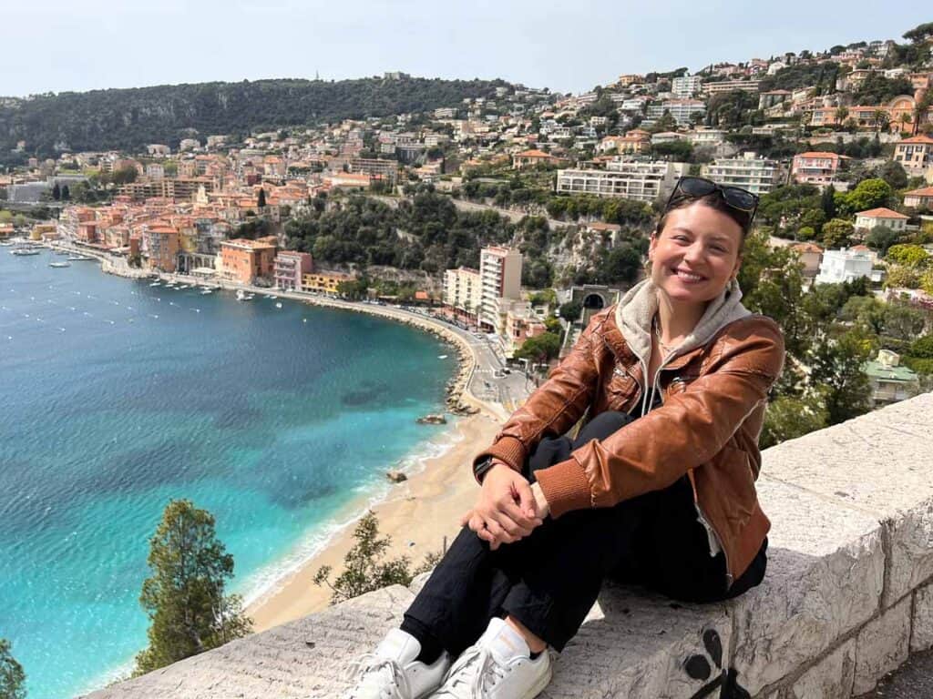 girl sitting on wall overlooking Villefranche-sur-Mer