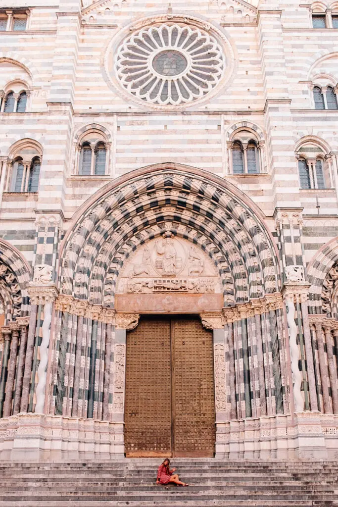 a girl sitting on the steps of San Lorenzo Cathedral in Genoa