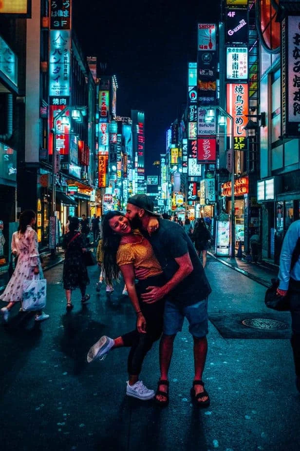 A couple in front of lights in Tokyo, Japan at night
