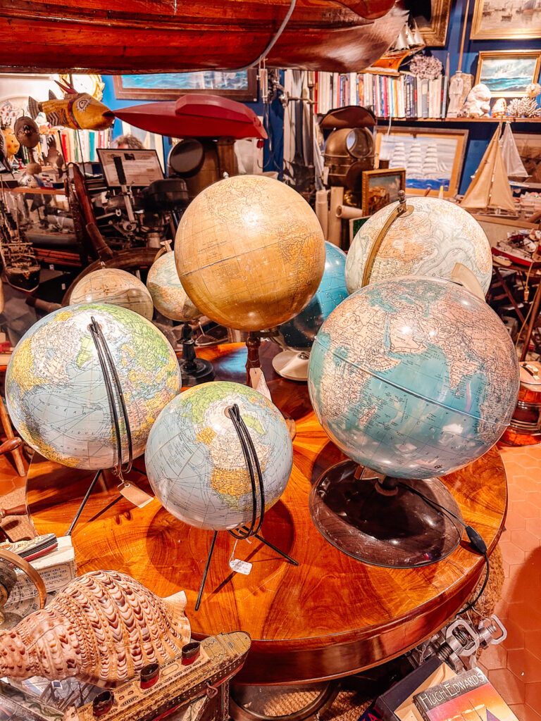 Old globes and vintage curiosities in a crowded antique shop in Saint-Tropez